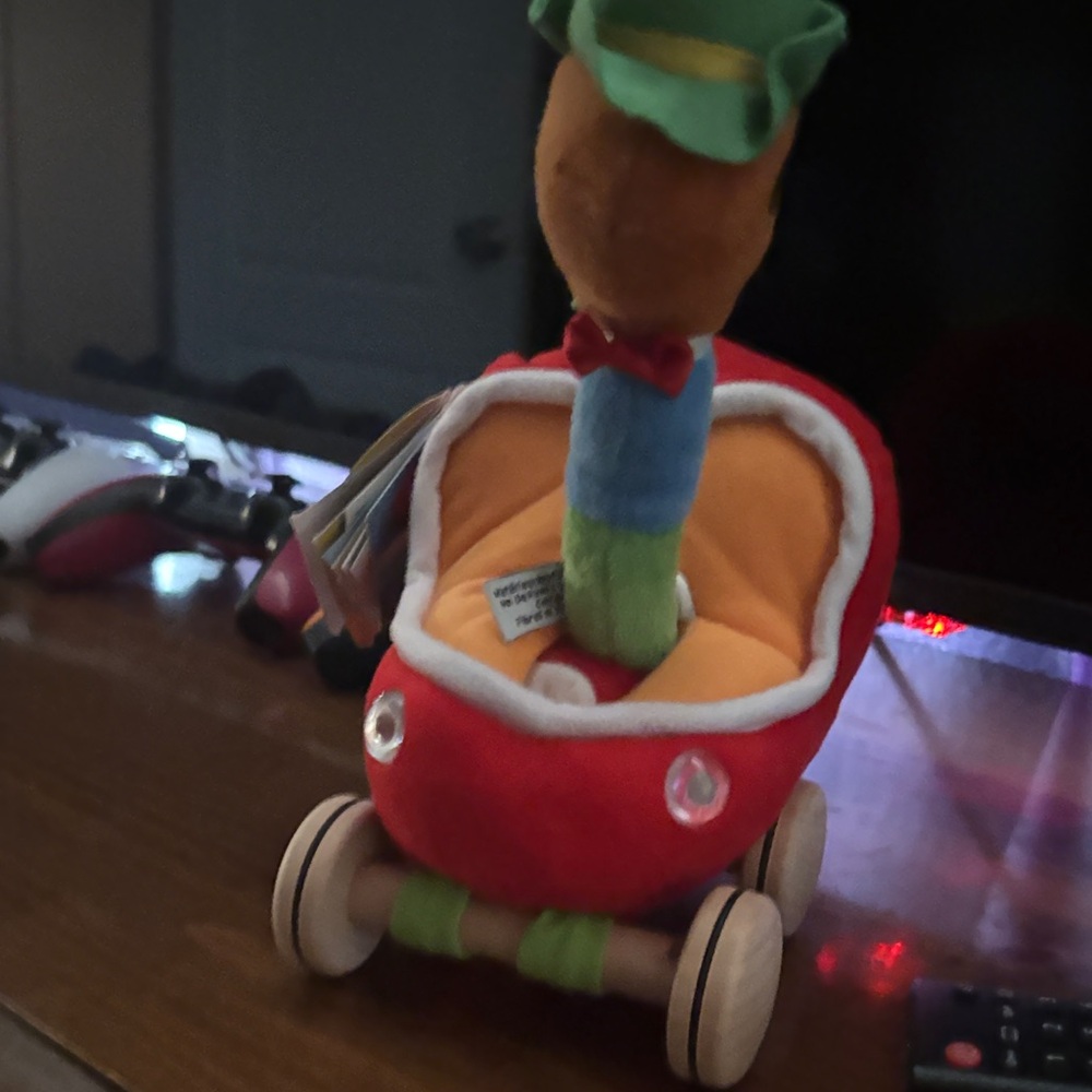 Red Plush Stroller Toy with Orange Interior and Colorful Plush Character
